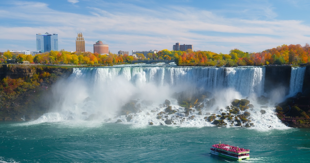 Niagara Falls. A pleasure boat with people near the huge famous waterfall. View from the Canadian side. Nature scenery. Photo for advertising.